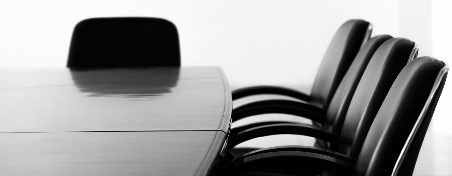 Boardroom table with empty chairs