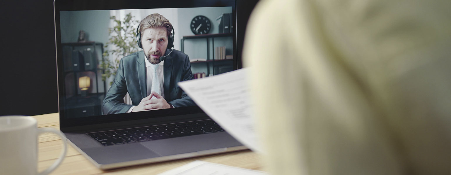 Over the shoulder view of person on laptop in video call