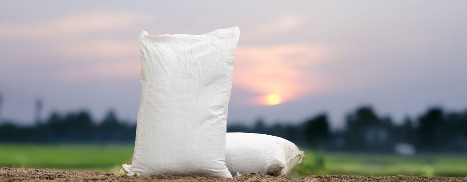 Fertilizer bag with sun setting in background